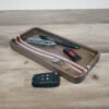 Walnut catchall tray with maple and purpleheart ocean wave stripe and everyday carry items.